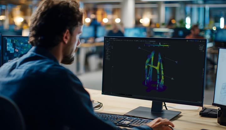 Image showing a man working on a computer with Onshape Simulation on the screen.