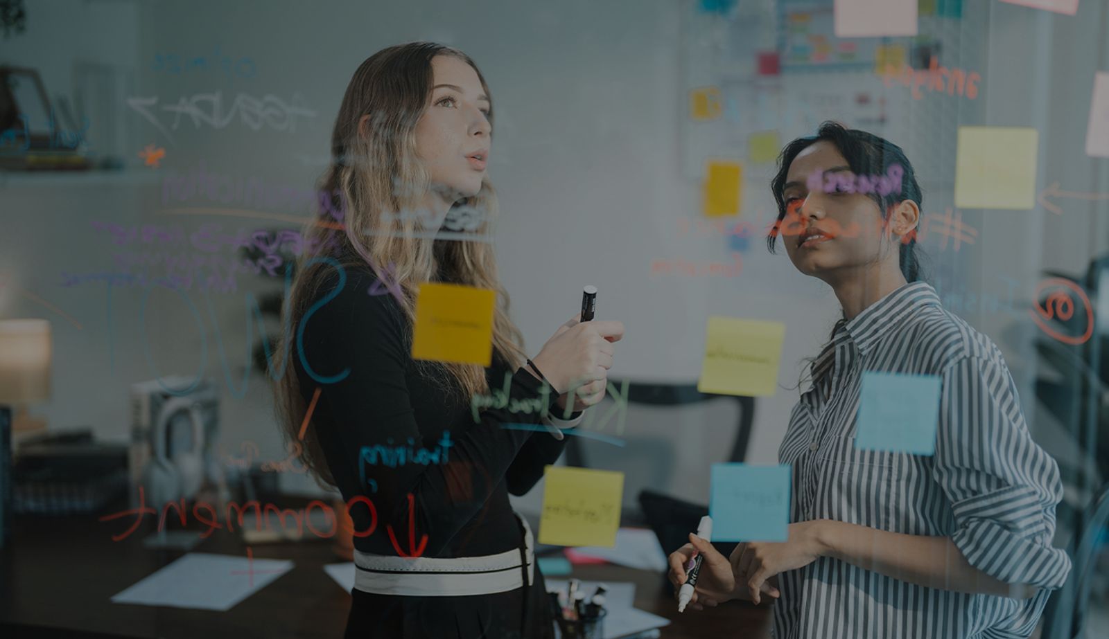Stock image with an overlay showing two colleagues discussing agile workflows.